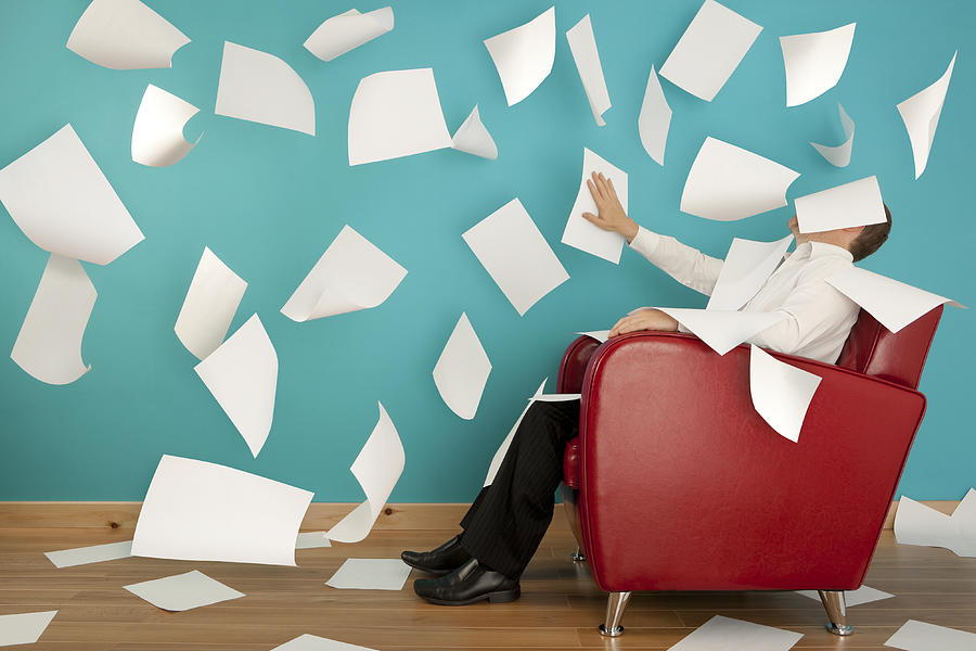Man sitting in red chair with papers flying all around him Photograph by mrPliskin