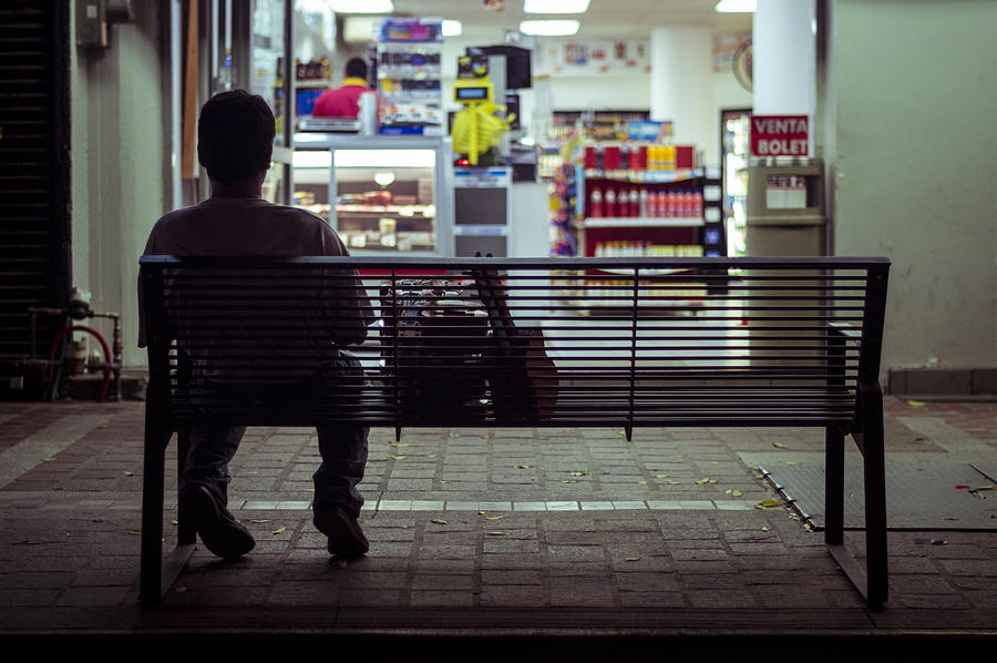 Man sitting on city bench at night Photograph by Paco Navarro
