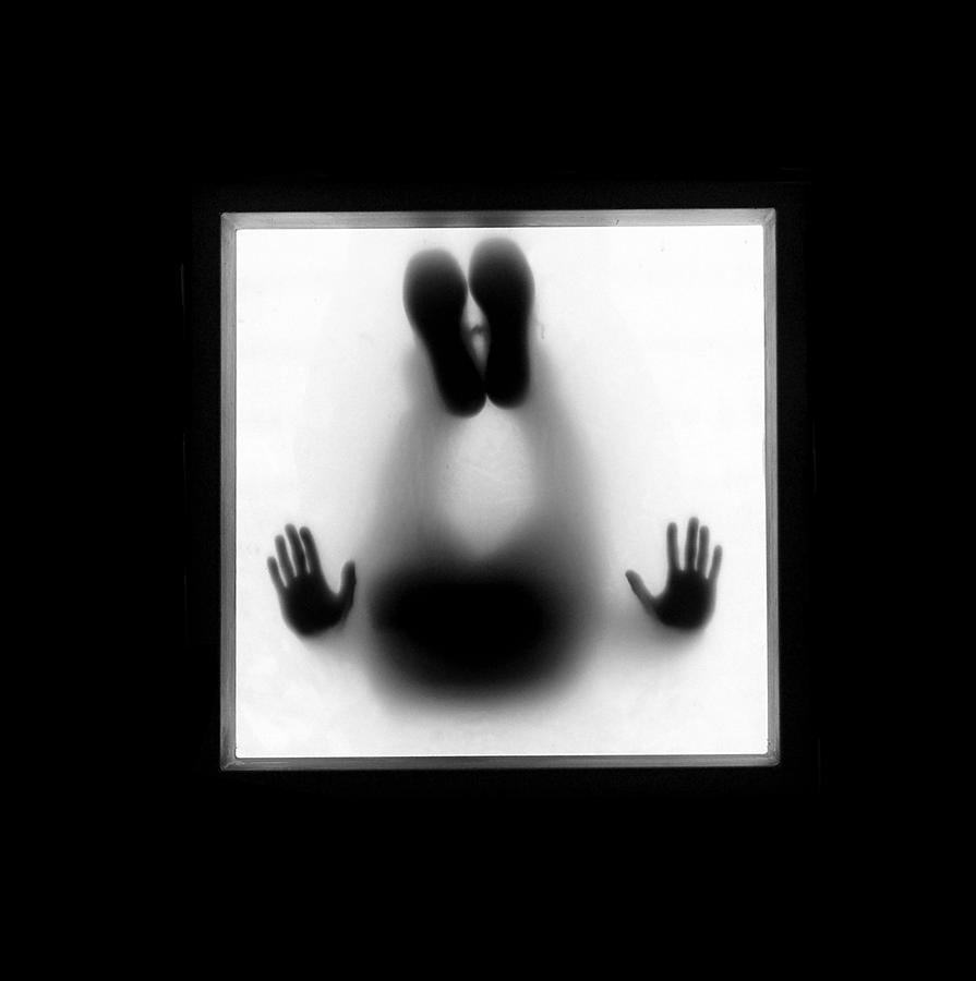 Man sitting on frosted glass, viewed from below Photograph by Cati Kaoe