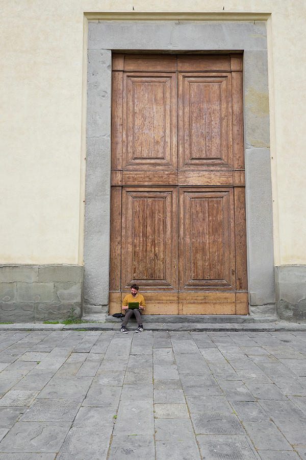 Man sitting on the stoop of the large wooden doors Photograph by David L Moore