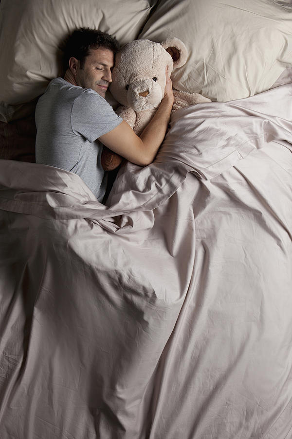 Man sleeping in bed with his teddy bear Photograph by Vincent Besnault