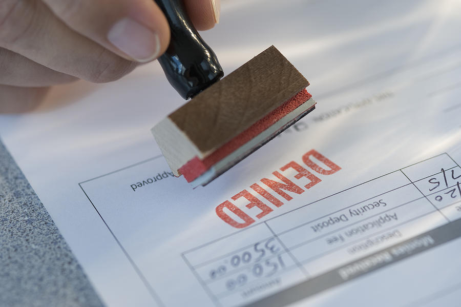 Man stamping denied on mortgage application Photograph by Tetra Images