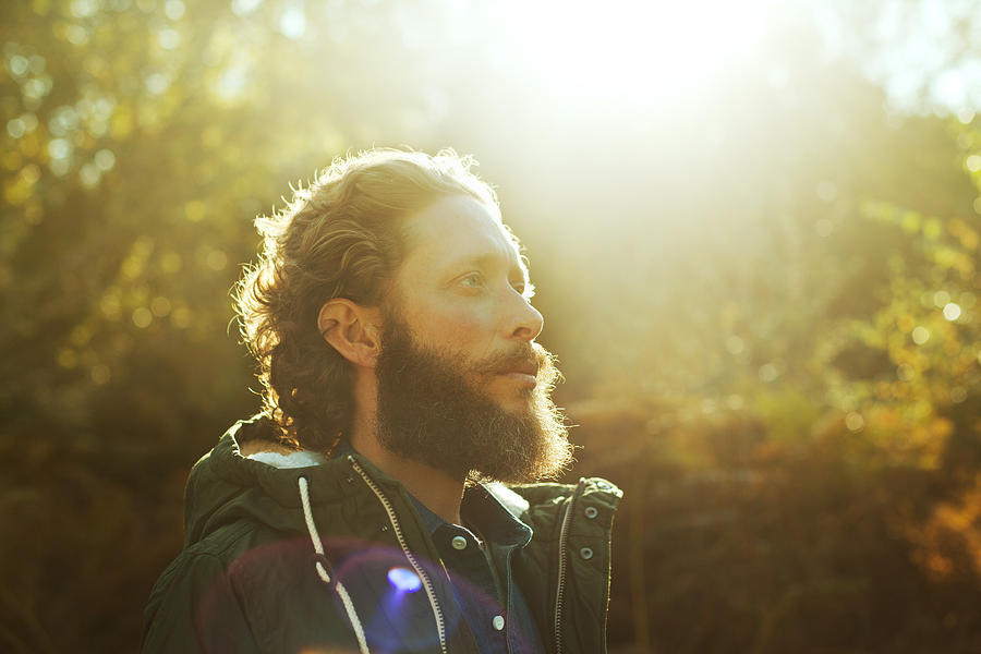 Man standing in sunlight in forest Photograph by Lilly Roadstones