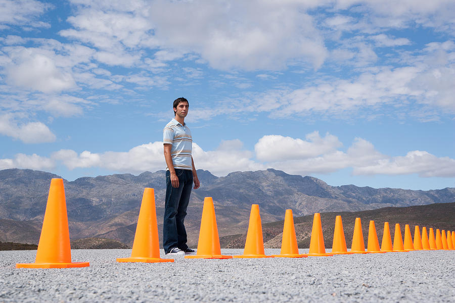 Man standing near traffic cones in outdoors   Photograph by Martin Barraud