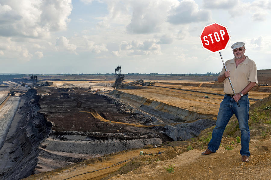 Man standing on the edge of an open pit, holding up a stop sign, Grevenbroich, North Rhine-Westphalia, Germany, Europe Photograph by Fhr