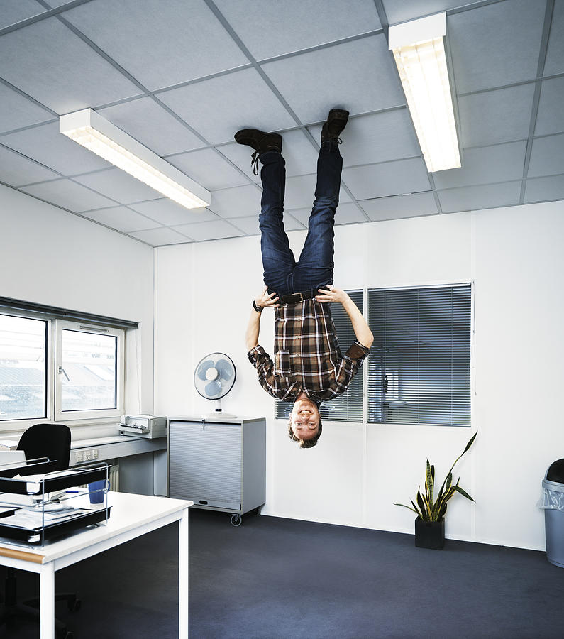 Man standing upside down on the ceiling. Photograph by Henrik Sorensen