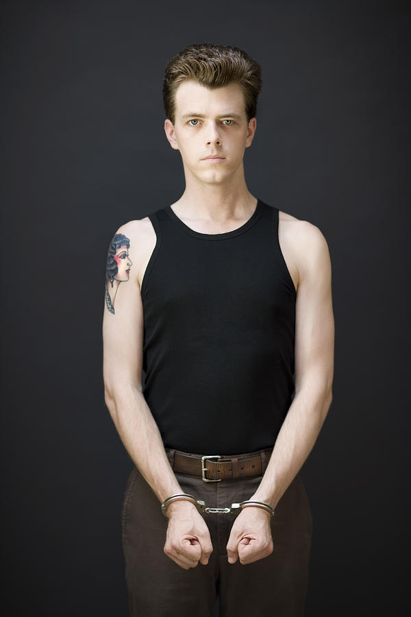 Man standing with handcuffs, portrait Photograph by David Sacks