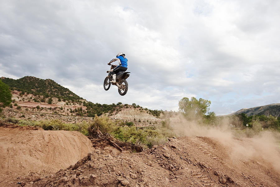 Man takin goff a dirt jump, on his motocross bike. Photograph by Daniel Milchev