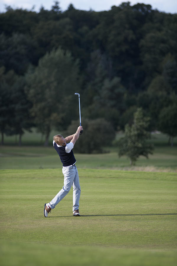 Man taking shot on golf course. Photograph by Dougal Waters
