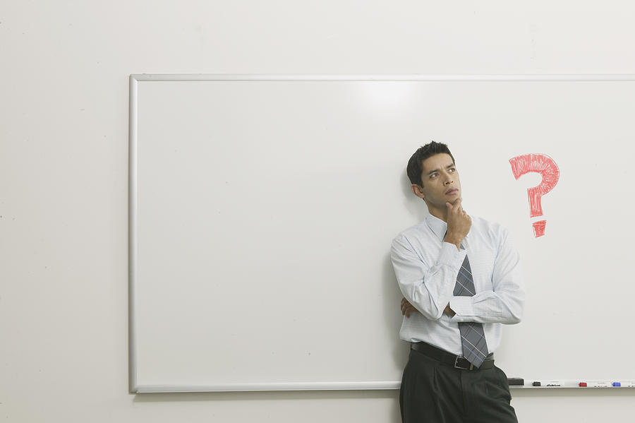 Man thinking in front of white board Photograph by Brand X Pictures