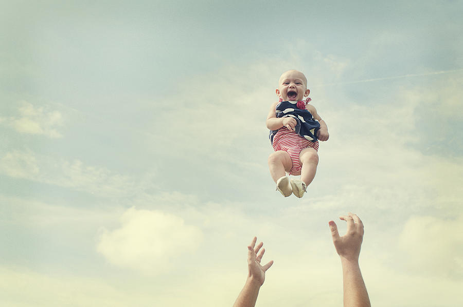 Man throwing baby in air Photograph by Jade Brookbank