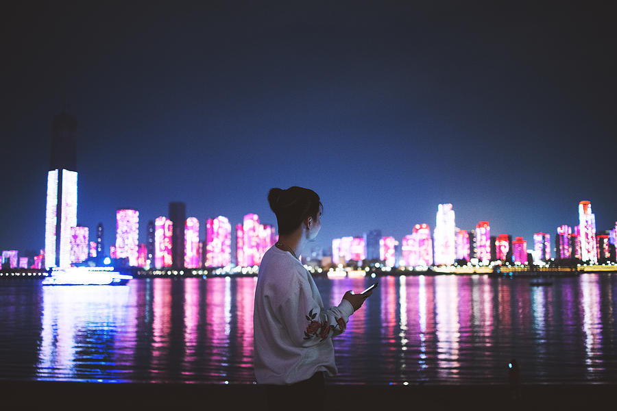 Man using a mobile phone in the city at night Photograph by Qi Yang