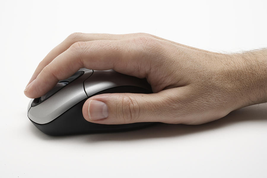 Man using computer mouse, close-up of hand, side view Photograph by Thomas Northcut