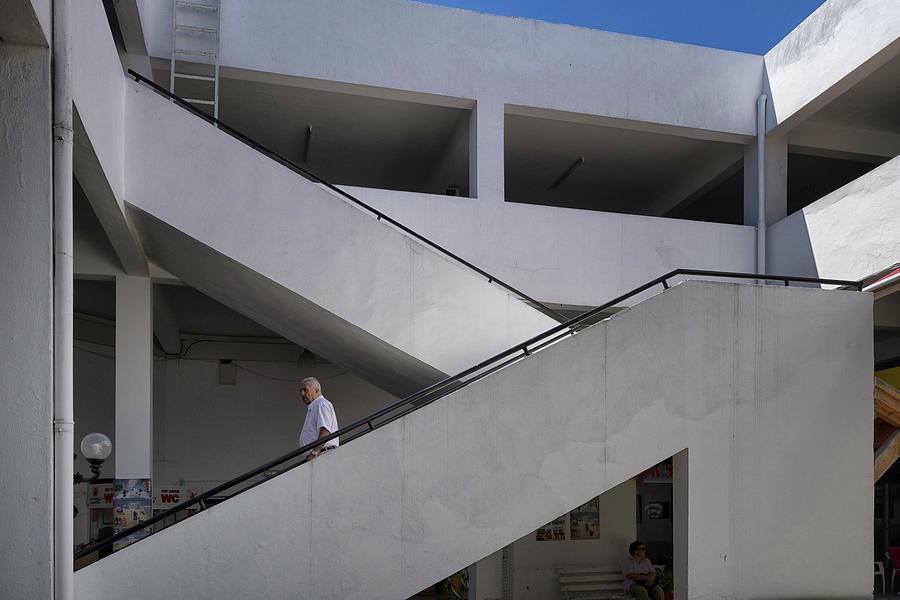 Man walking down the stairs in an office building in Cesme. Photograph by Emreturanphoto