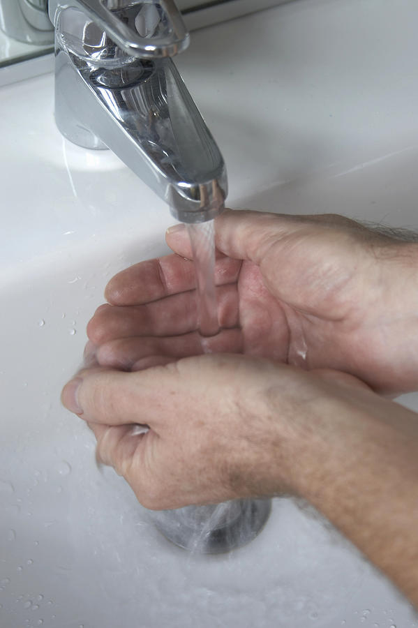 Man washing hands, close-up Photograph by Andrew Holt