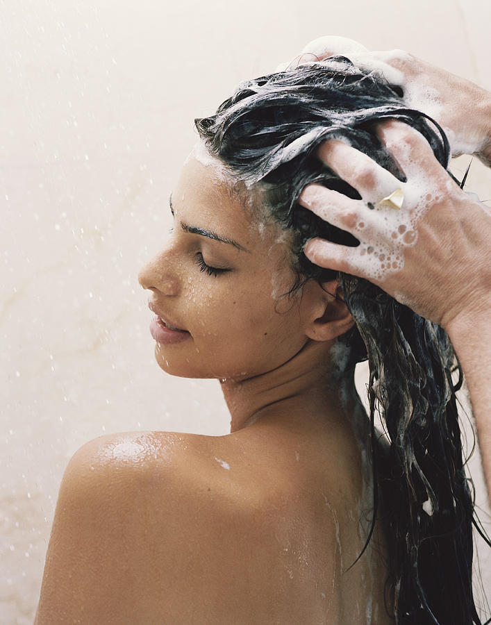 Man washing young womans hair, close-up Photograph by Roger Wright
