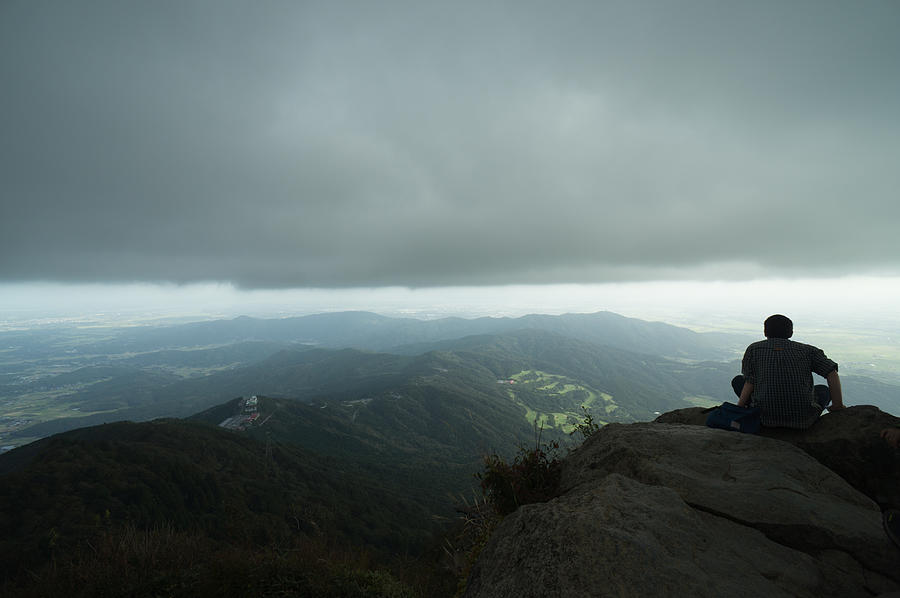 Man watching typhoon clouds on mountain summit Photograph by Ippei Naoi