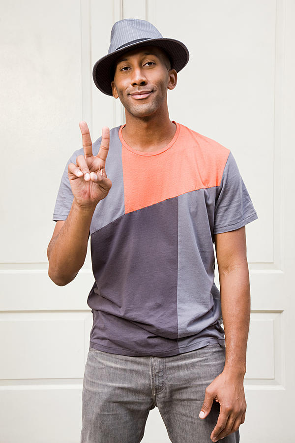 Man wearing fedora and doing peace sign Photograph by Image Source