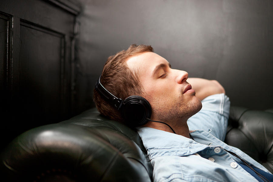 Man wearing headphones listening to music Photograph by Image Source