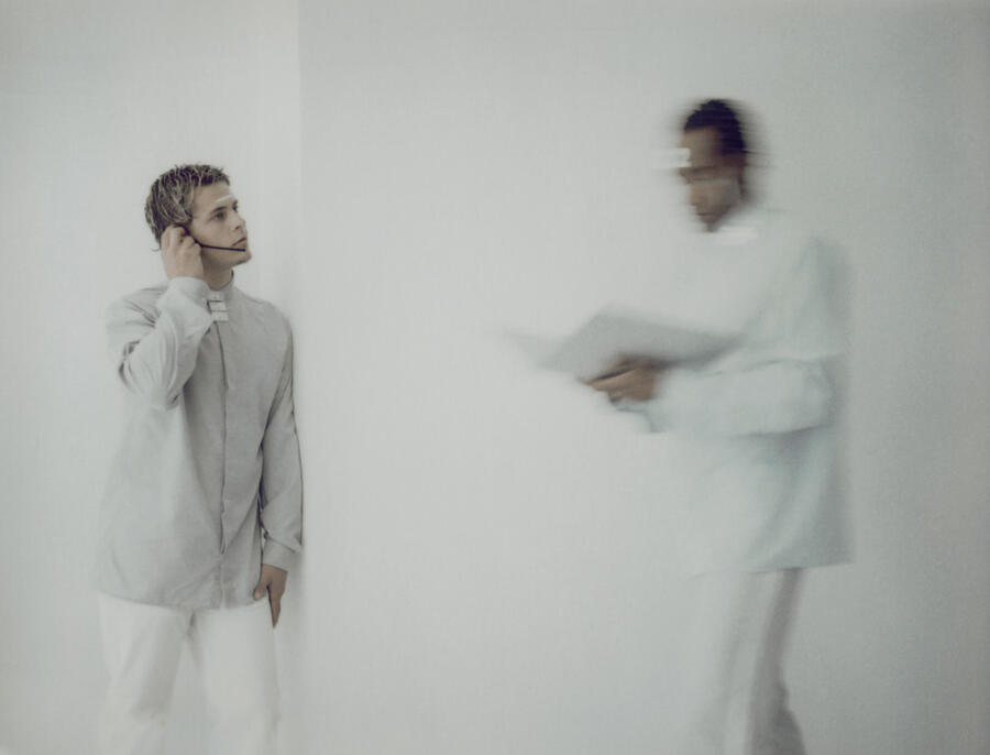 Man wearing headset, other man carrying documents, blurred motion Photograph by Matthieu Spohn