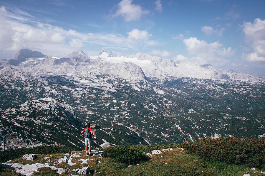 Man with a backpack looks at the Dachstein massif Photograph by Vaclav Sonnek