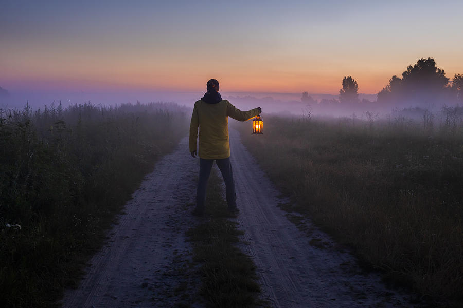 Man with a lantern in the fog. Photograph by Anton Petrus
