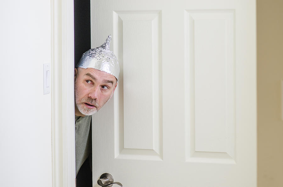 Man with aluminum foil hat behind door Photograph by Marc Dufresne