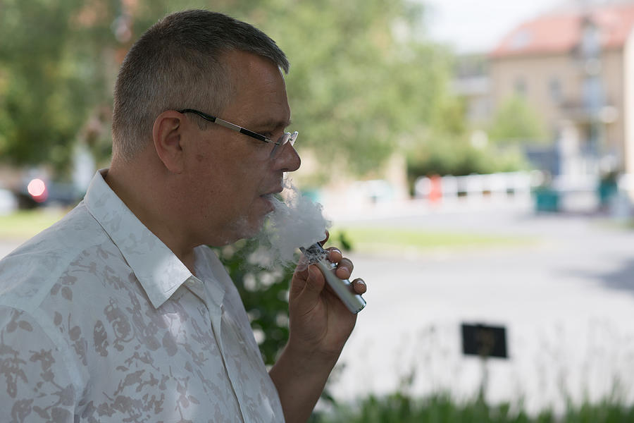 Man with casual look smoking e-cigarette Photograph by Jean-Marc PAYET