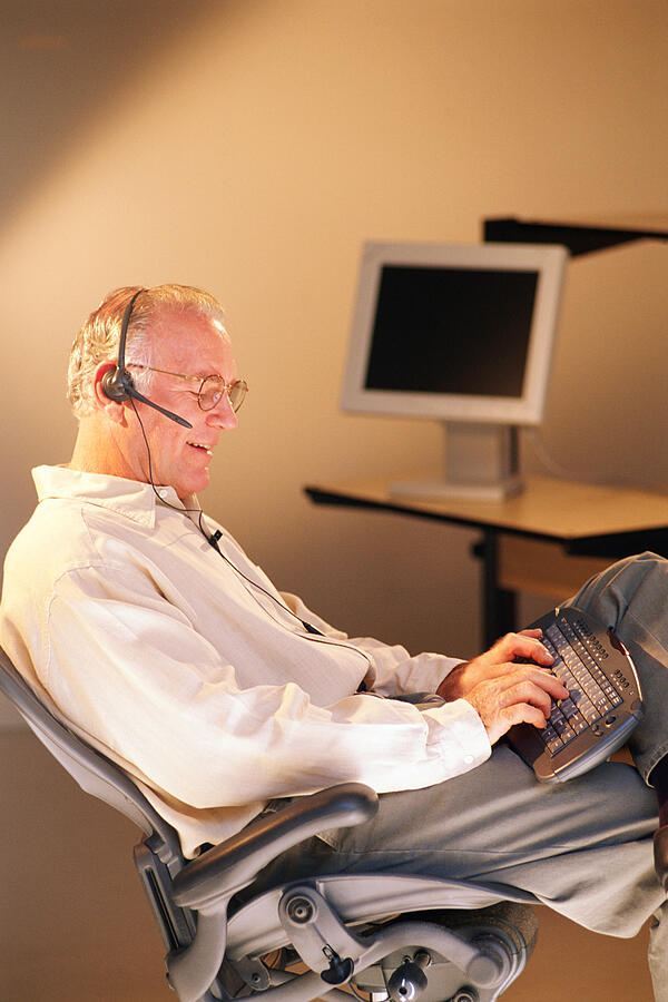 Man with computer and headset Photograph by Thinkstock