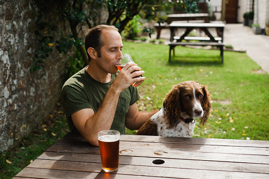 Man  with dog in pub garden Photograph by Suzanne Marshall