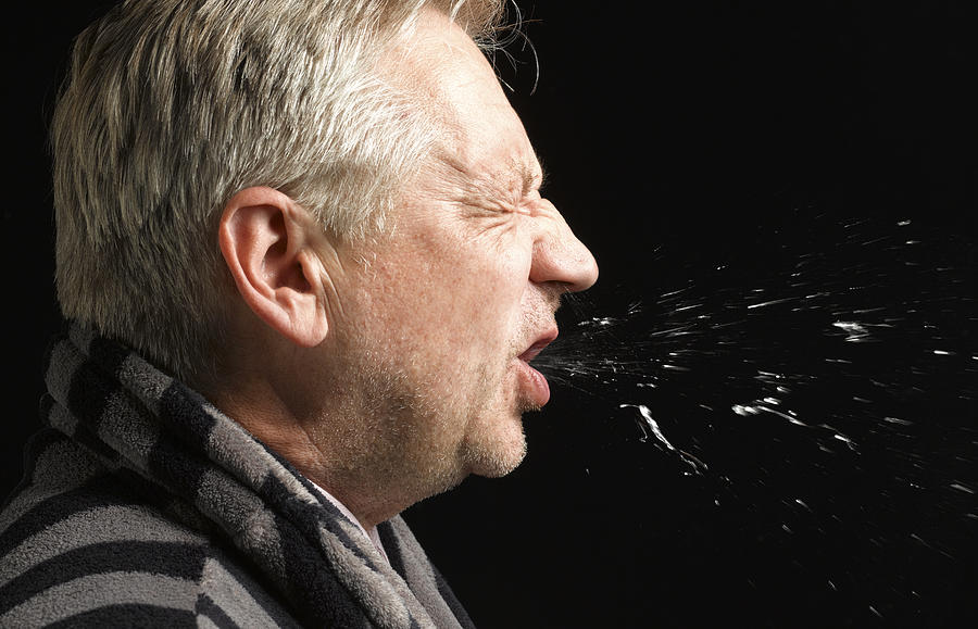 Man with flu coughing and sneezing Photograph by Peter Dazeley