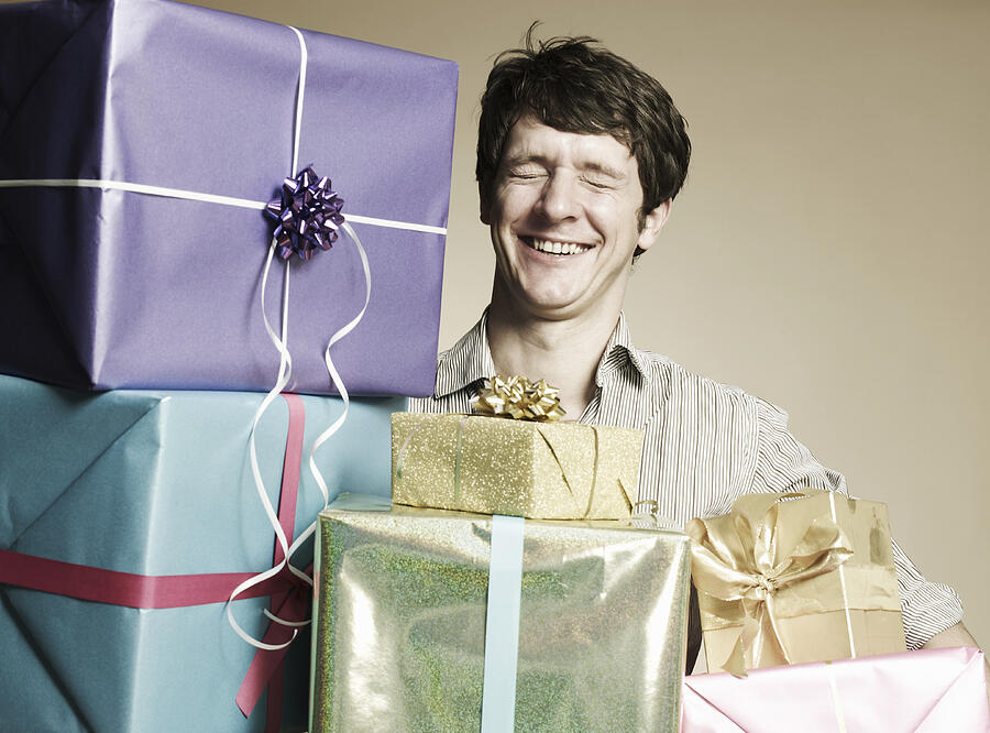 Man with gift boxes, eyes closed, smiling Photograph by Flashpop