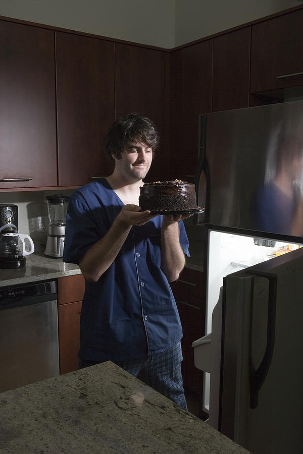 Man Withrefrigerator Holding Chocolate Cake Photograph by Sheer Photo, Inc