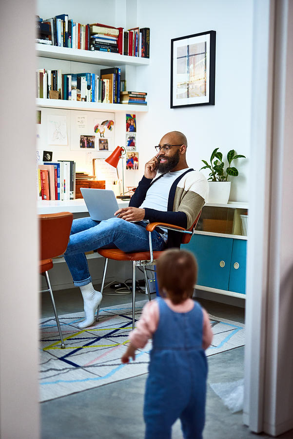 Man working in home office with daughter in doorway Photograph by 10000 Hours Man working in home office with daughter in doorway Photograph by 10000 Hours