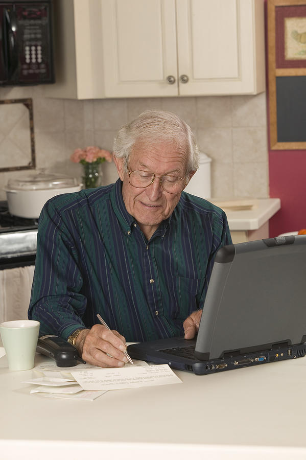 Man writing and using laptop Photograph by Comstock Images