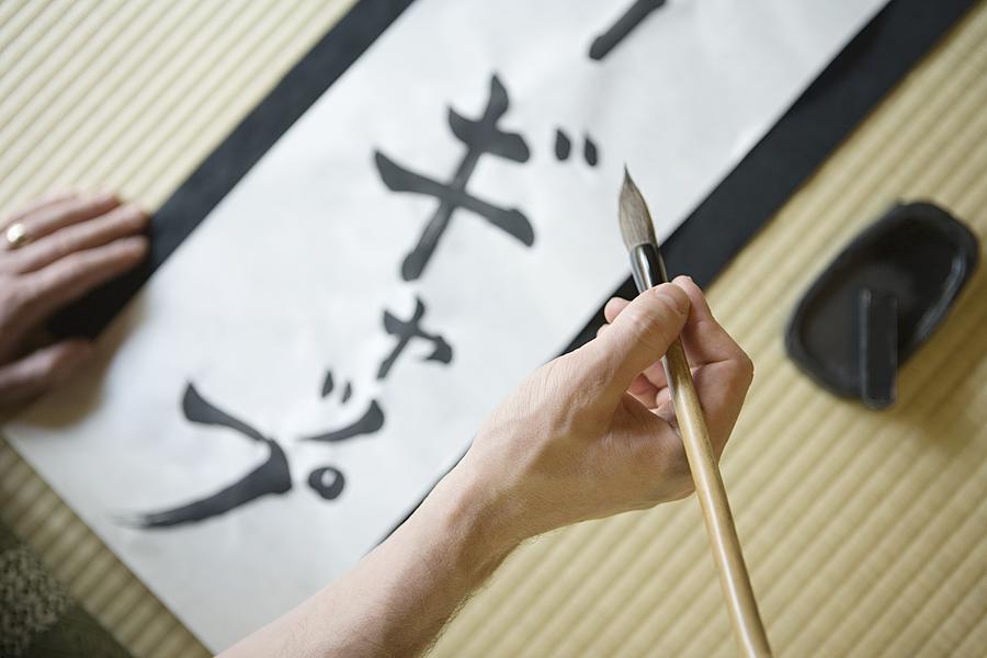 Man writing in Japanese script Photograph by Image Source