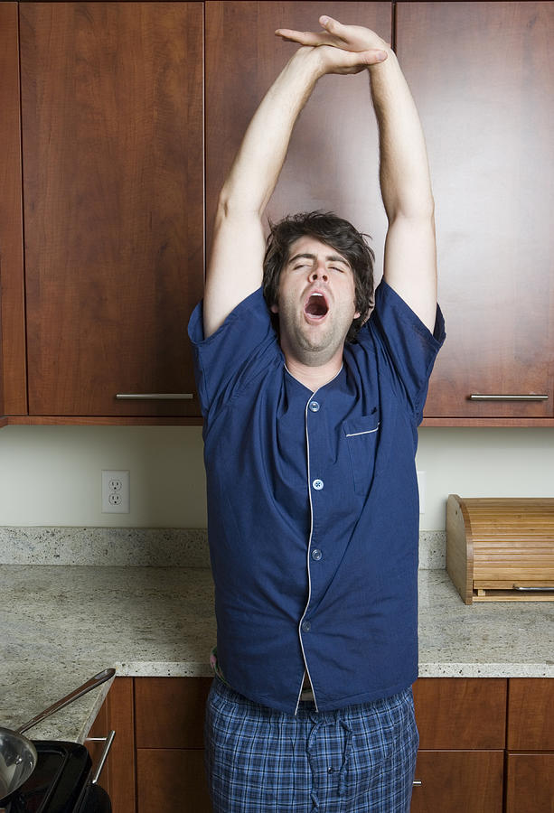Man Yawning And Stretching In Kitchen  Photograph by Sheer Photo, Inc