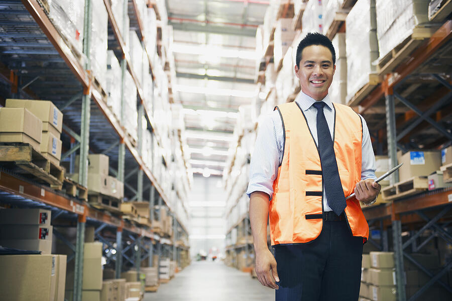 Manager holding digital tablet in warehouse Photograph by Jacobs Stock Photography Ltd