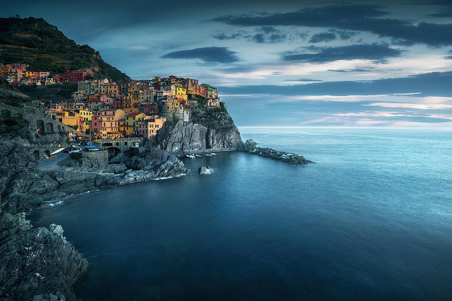 Manarola village, rocks and sea in blue hour. Cinque Terre, Ital Photograph by Stefano Orazzini
