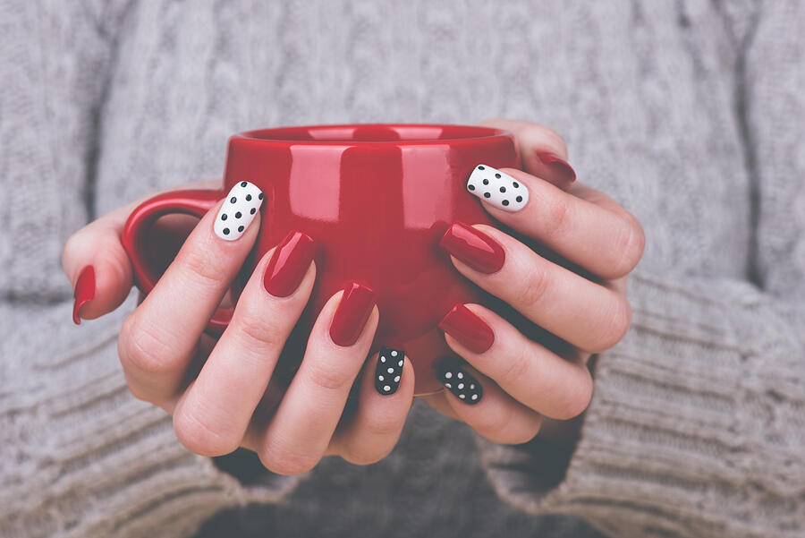 Manicured womans hands holding cup Photograph by Flufi