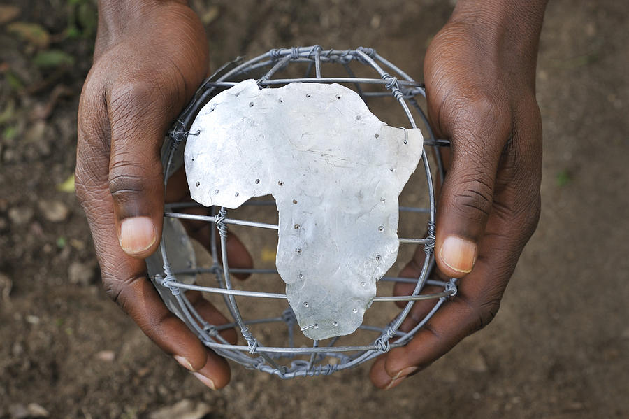 Mans hands holding wire globe showing Africa Photograph by Dimitri Otis