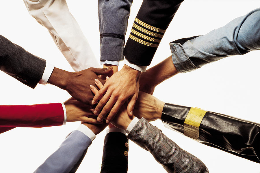 Many diverse hands stacked on one another shows unity Photograph by Comstock