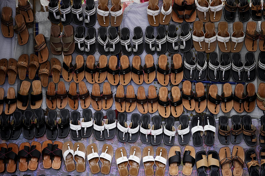Many leather sandals on display at market. Photograph by Asia Images