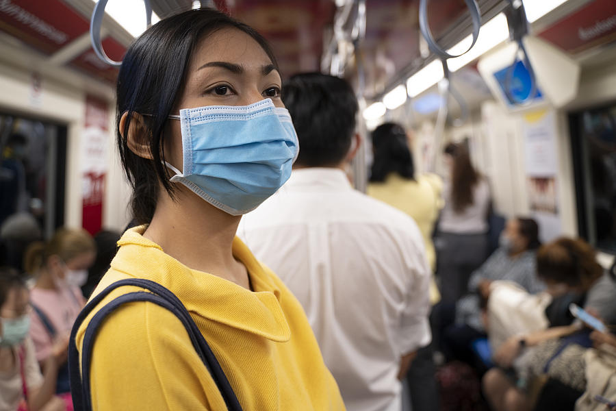 Masked girl to protect herself from Covid 19 virus in public area Photograph by seksan Mongkhonkhamsao