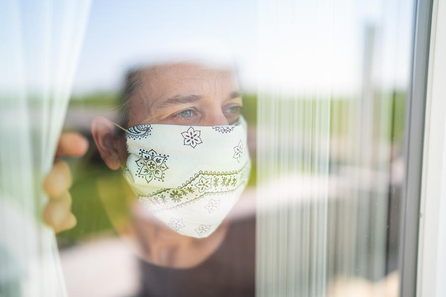 Mature Adult Woman With Mouse Nose Mask Looking Out Through The Window Photograph by Amriphoto