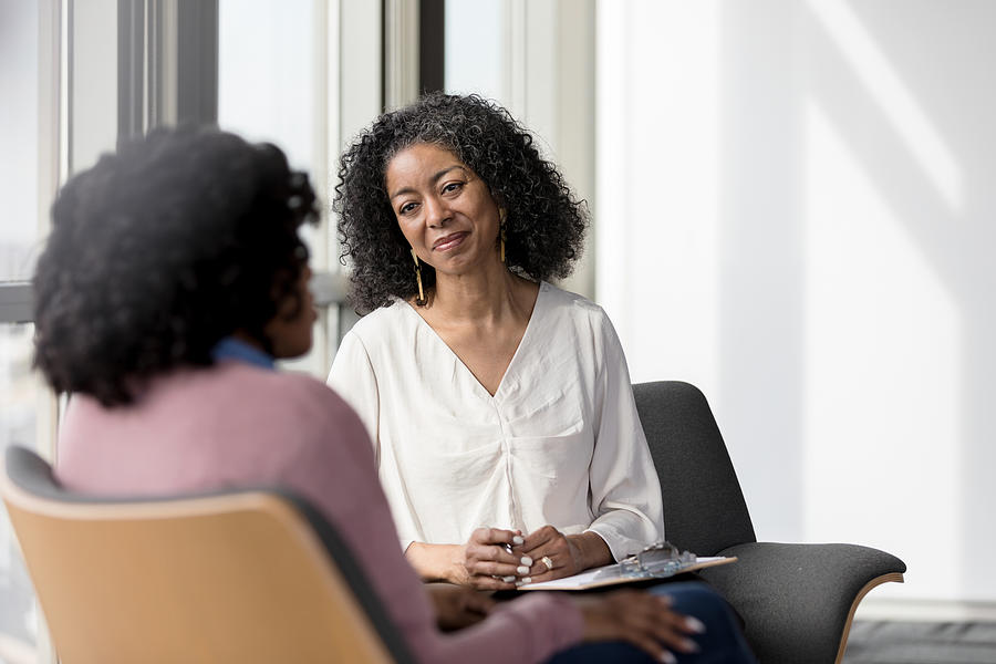 Mature counselor listens compassionately to unrecognizable female client Photograph by SDI Productions