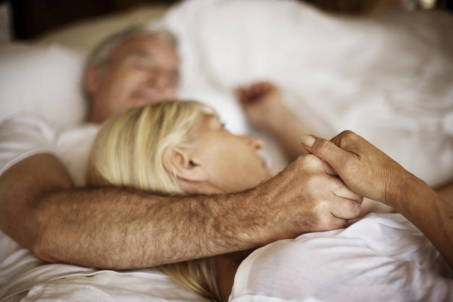 Mature couple embracing in bed Photograph by Thomas Tolstrup