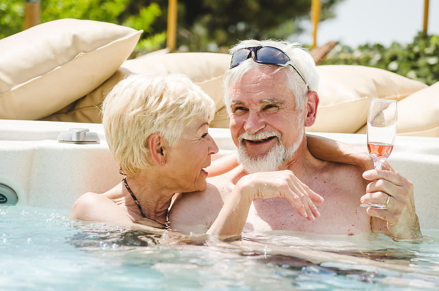 Mature Couple Having Fun Togetherness In The Pool Photograph by Franckreporter