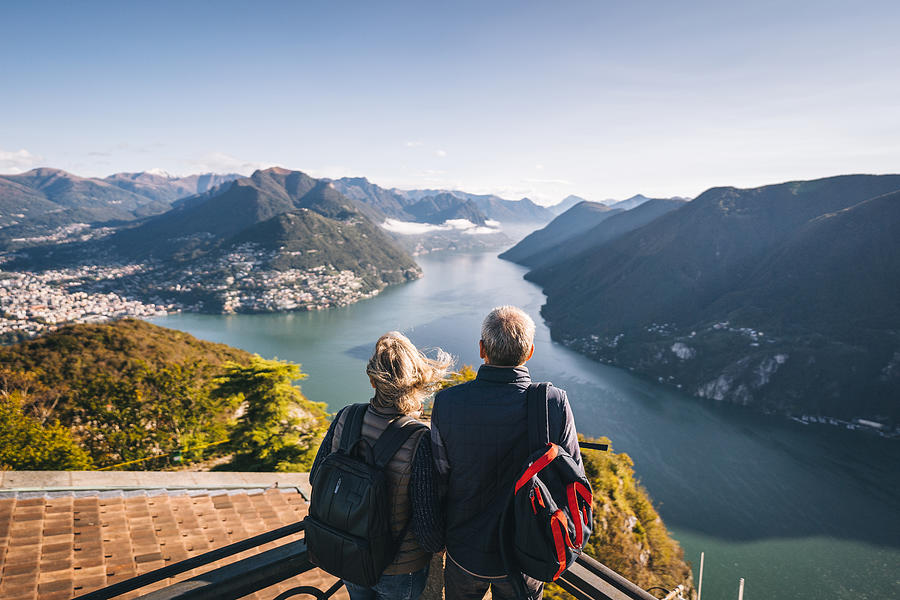 Mature couple hike above lake Lugano in the morning Photograph by AscentXmedia