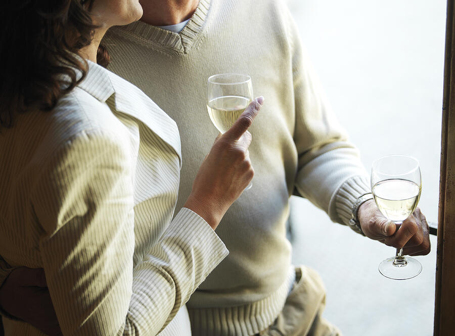 Mature couple holding wine glasses, mid section Photograph by Eileen Bach